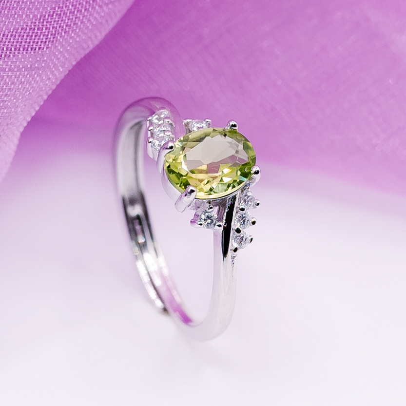 Self-adjustable 925 sterling silver engagement ring with oval-shaped natural peridot stone, crafted by Eternal Jewellery Zambia, symbolizing elegance and versatility.